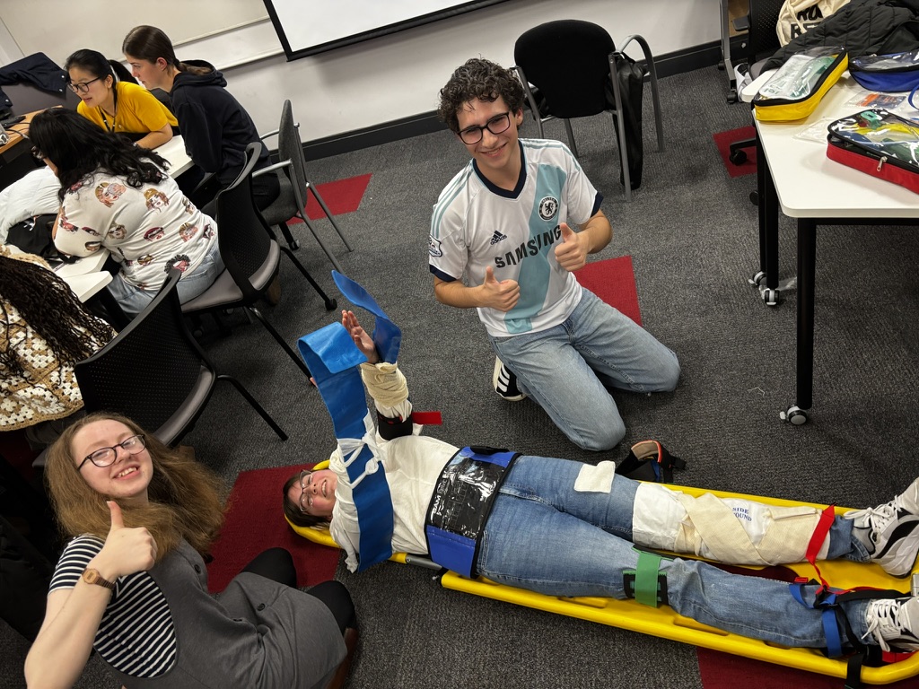Students practicing patient assessment and spinal care techniques